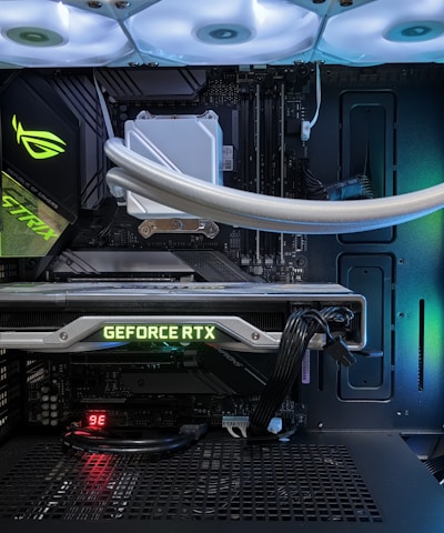 A high-end gaming or performance PC interior equipped with RGB lighting and multiple cooling fans. The graphics card prominently displayed is a GeForce RTX model, with branding visible. The setup includes neatly managed cables and a liquid cooling system.